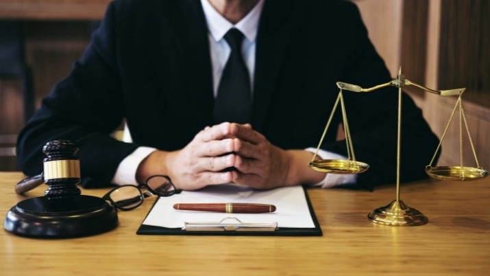 lawyer with gavel documents and justice scale in his table