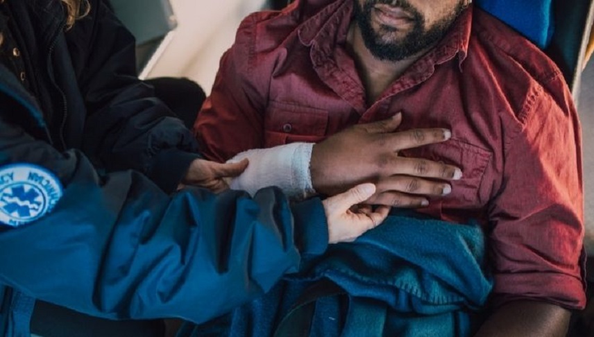 a man having a chest and hand injury assisted by a medic