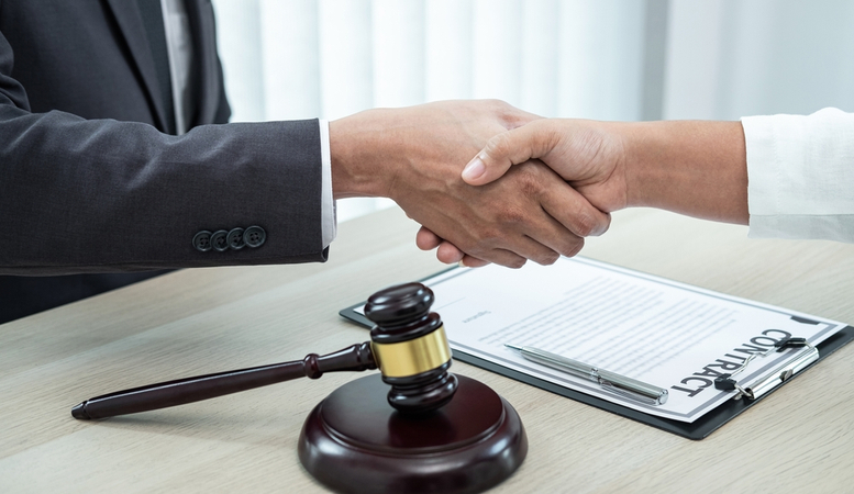 attorney hand shaking with client after a unpaid wage case win