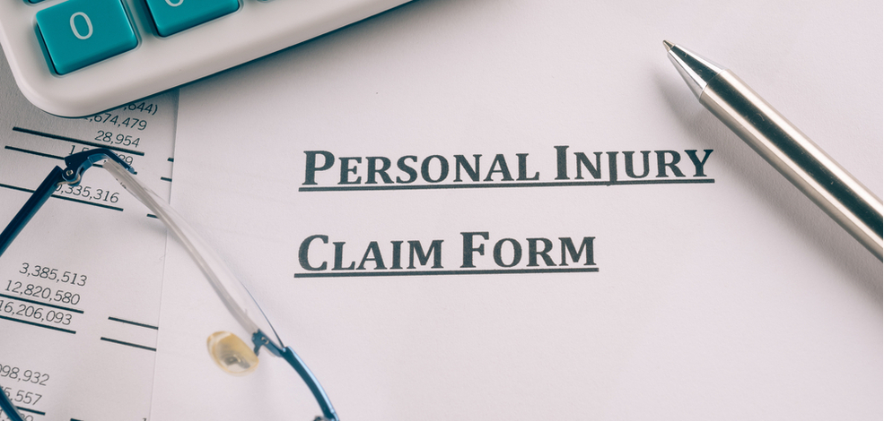 personal injury claim form with a pen and calculator