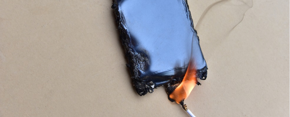 a burnt mobile phone with a charger connected