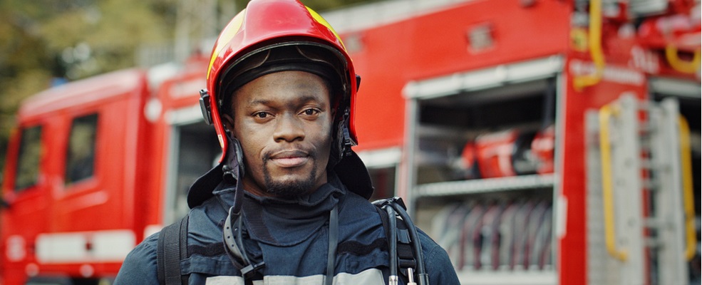 a firefighter standing beside a firetruck