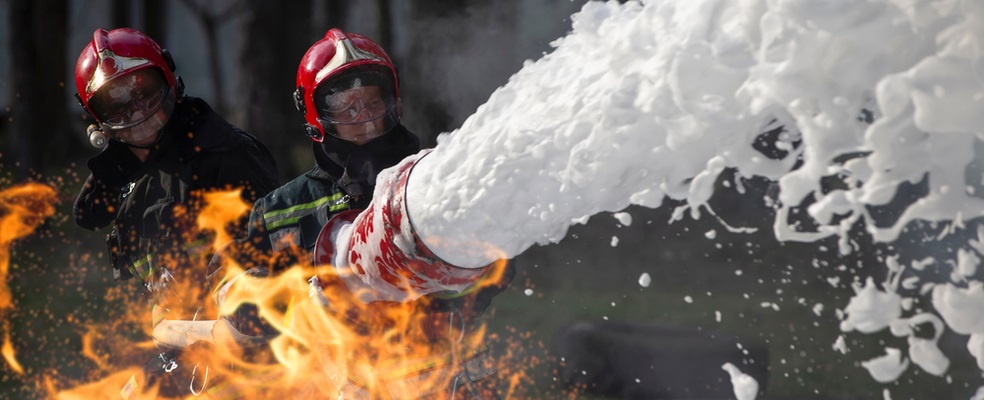 firefighter extinguishing a fire by foam