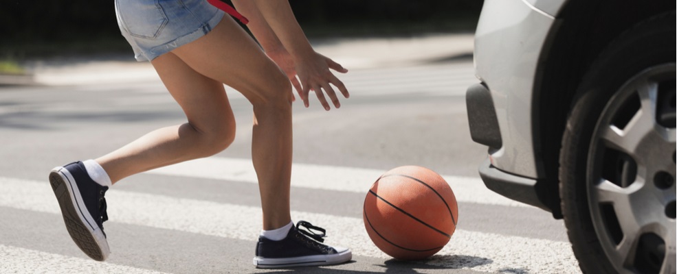 girl following a ball near to be hit by a car