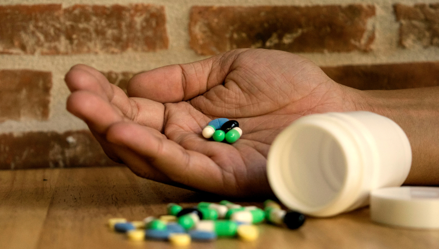 hand with wrong description drugs with a capsule bottle beside of it