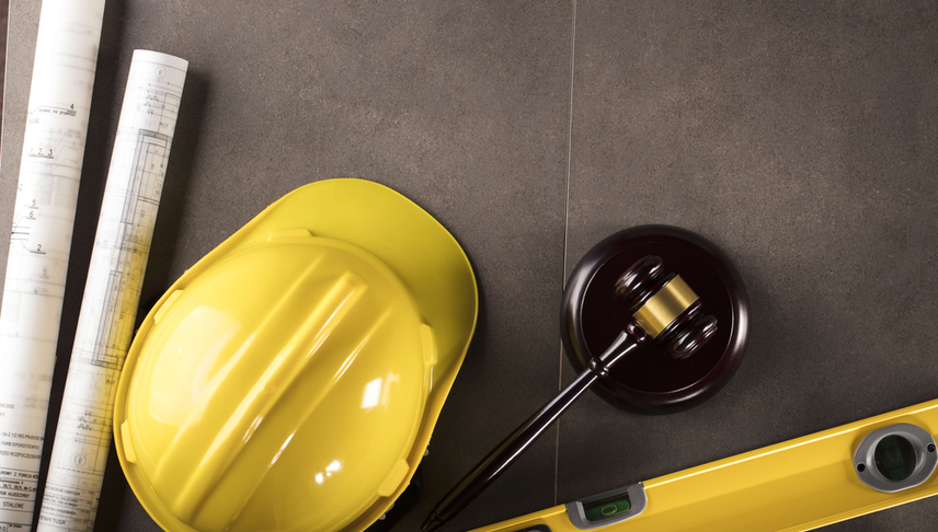 helmet construction drafts and a gavel illustrating construction law