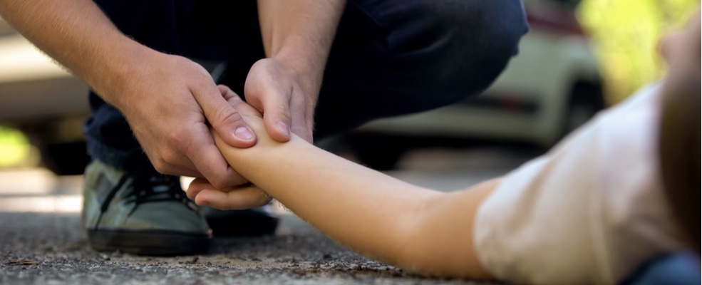 man checking a pulse of an unconscious woman