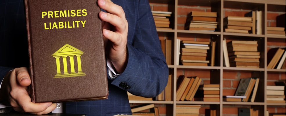 man holding premises liability law book