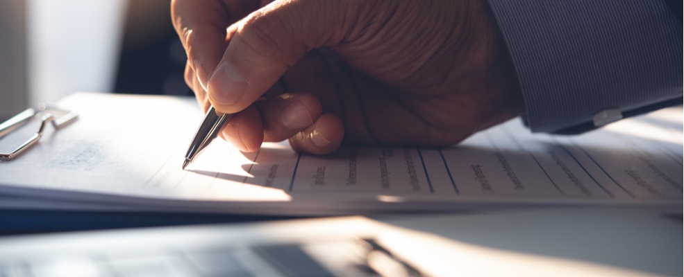 man signing a document after an accident