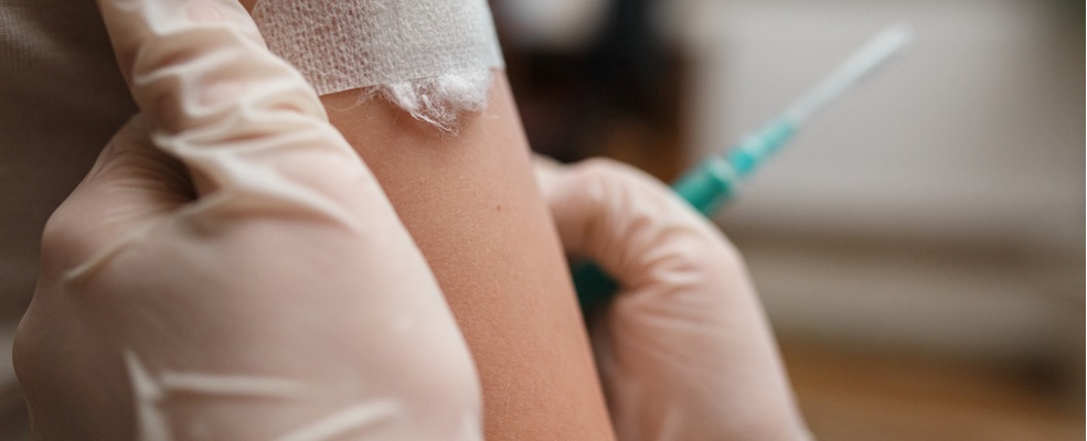 nurse putting a gauze into the area which have been vaccinated