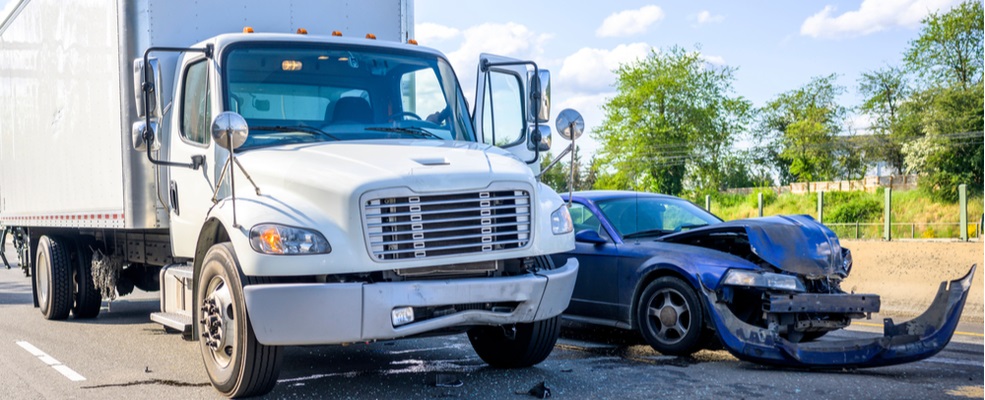 white truck and a car wreck after an accident