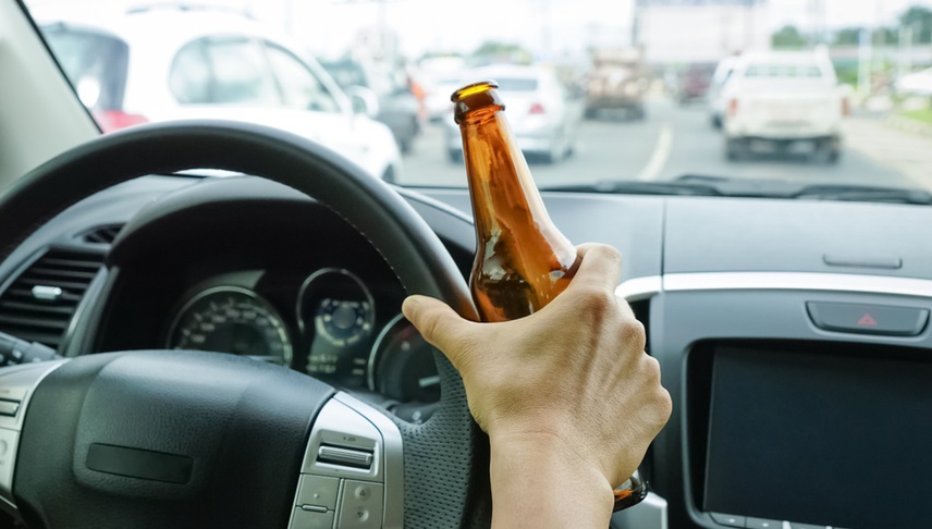 driver holding a bottle of beer while driving