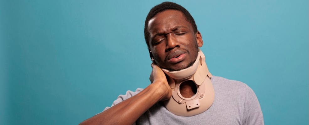 man in a neck brace feeling emotional and physical pain after car accident