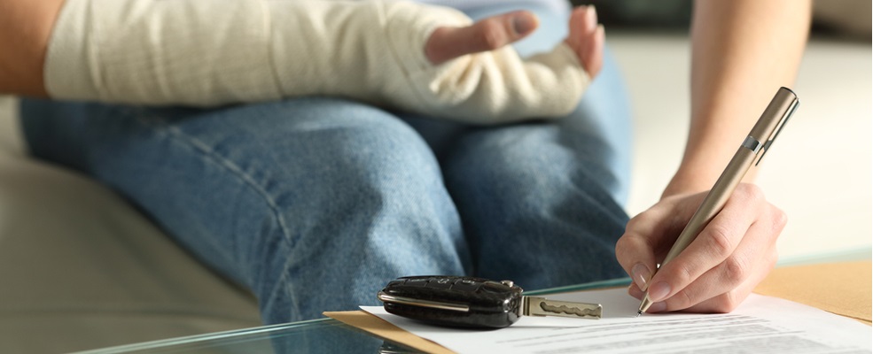 injured woman writing a document to file a car accident case