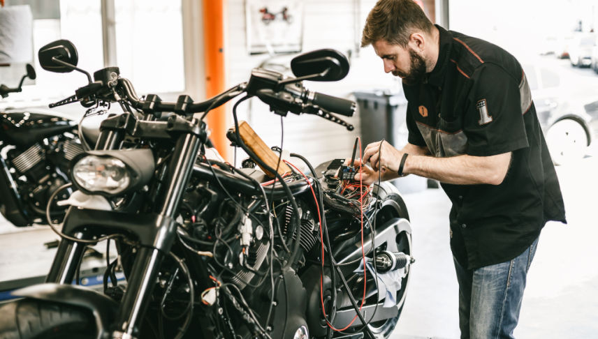 professional mechanic checking motorcyle for its regular maintenance