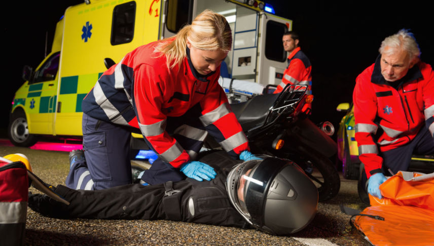 rescute team assisting injured man at motorcycle accident