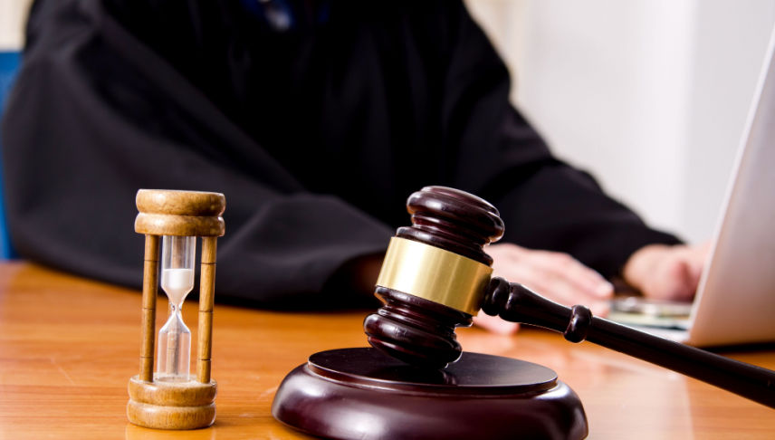 lawyer working on car accident settlement with gavel and hourglass on table