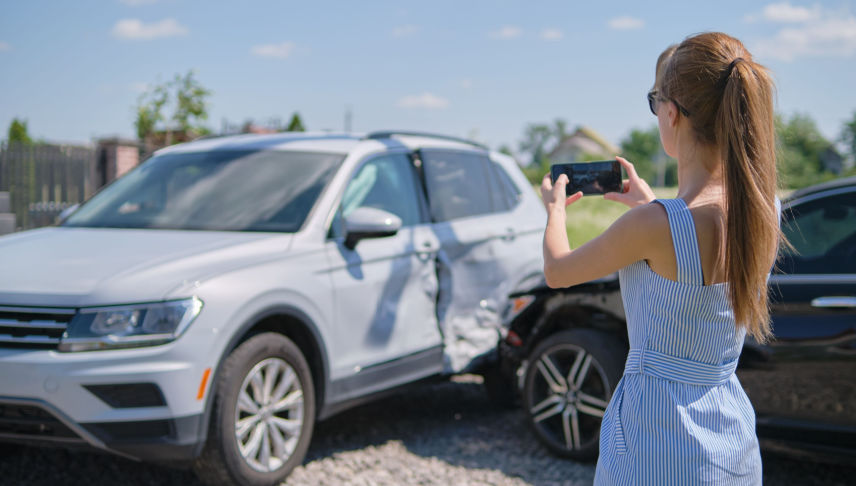 woman driver collecting evidence on mobile phone after car accident