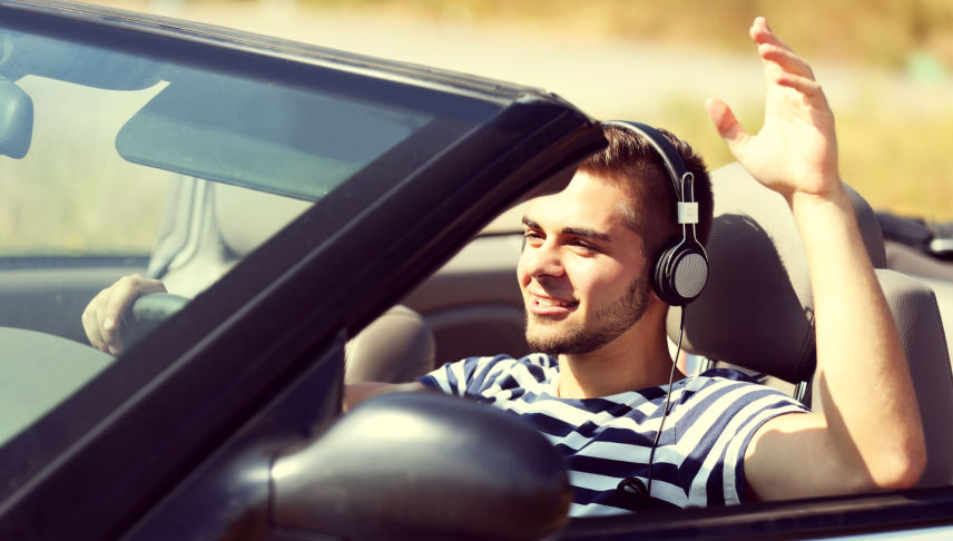 man driving car wearing headphones