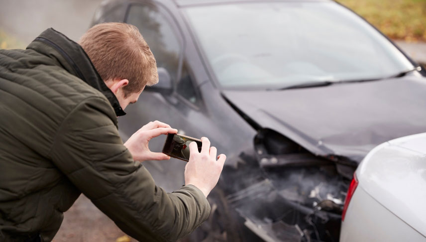 man gathering evidence after car accident