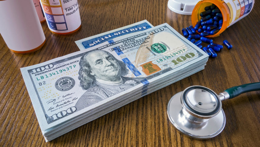 stack of us dollars medicines and stethoscope