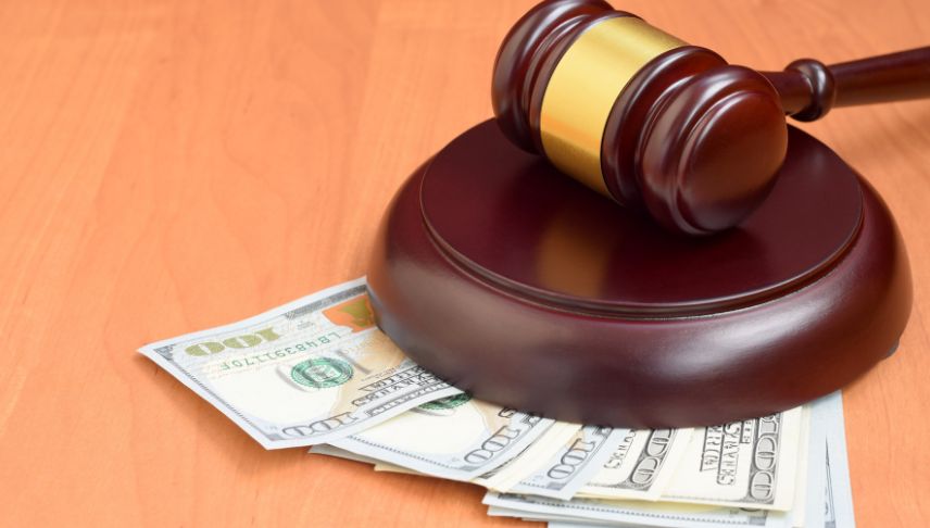judge gavel and dollar bills on brown wooden table