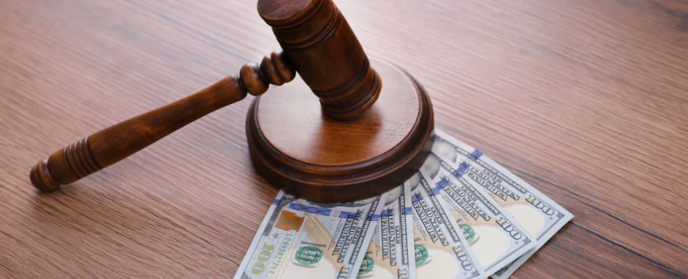 judge gavel and dollar bills on wooden table
