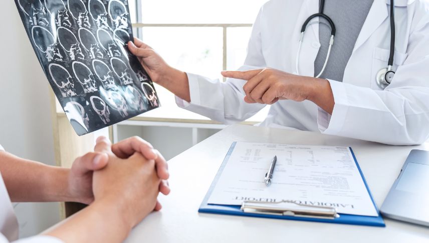 doctor holding and explaining CT scan result to patient