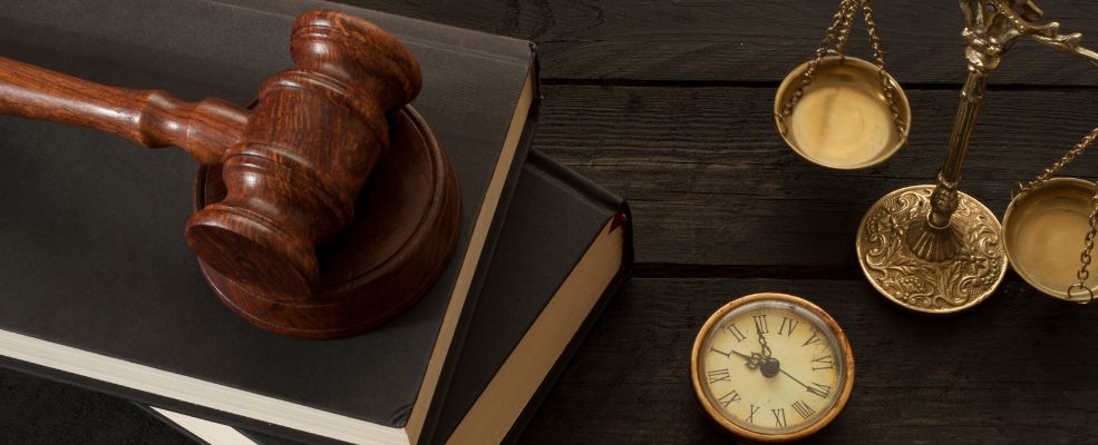 books gavel scale and clock on wooden table