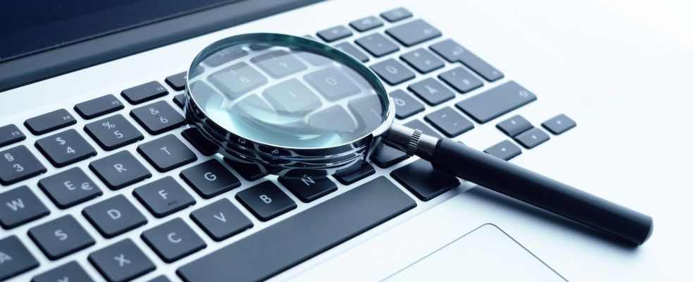 magnifying glass on silver laptop