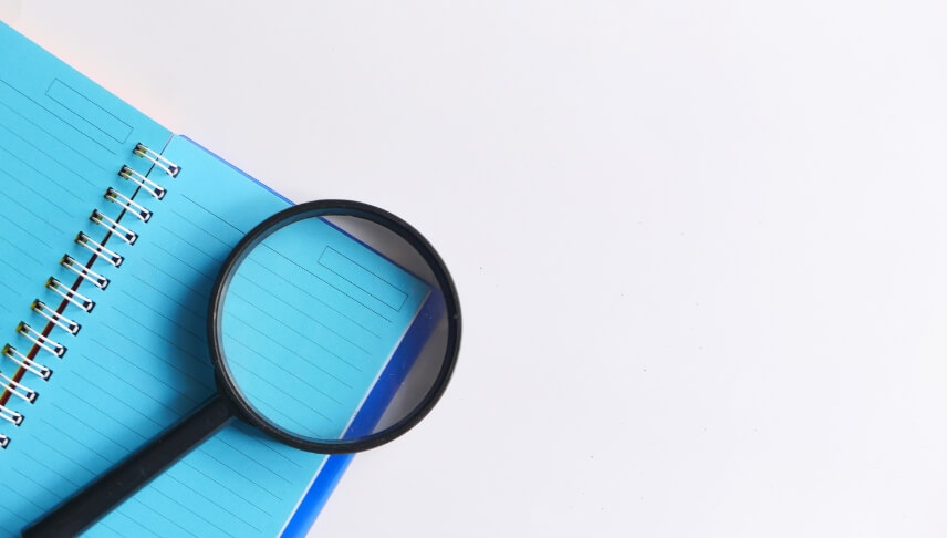 magnifying glass on top of notebook