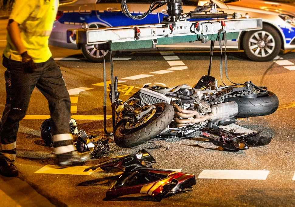 wrecked motorcycle being pulled from the road